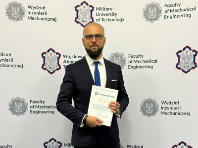 Fot. mgr inż. Radosław Ciepielewski z egzemplarzem rozprawy doktorskiej